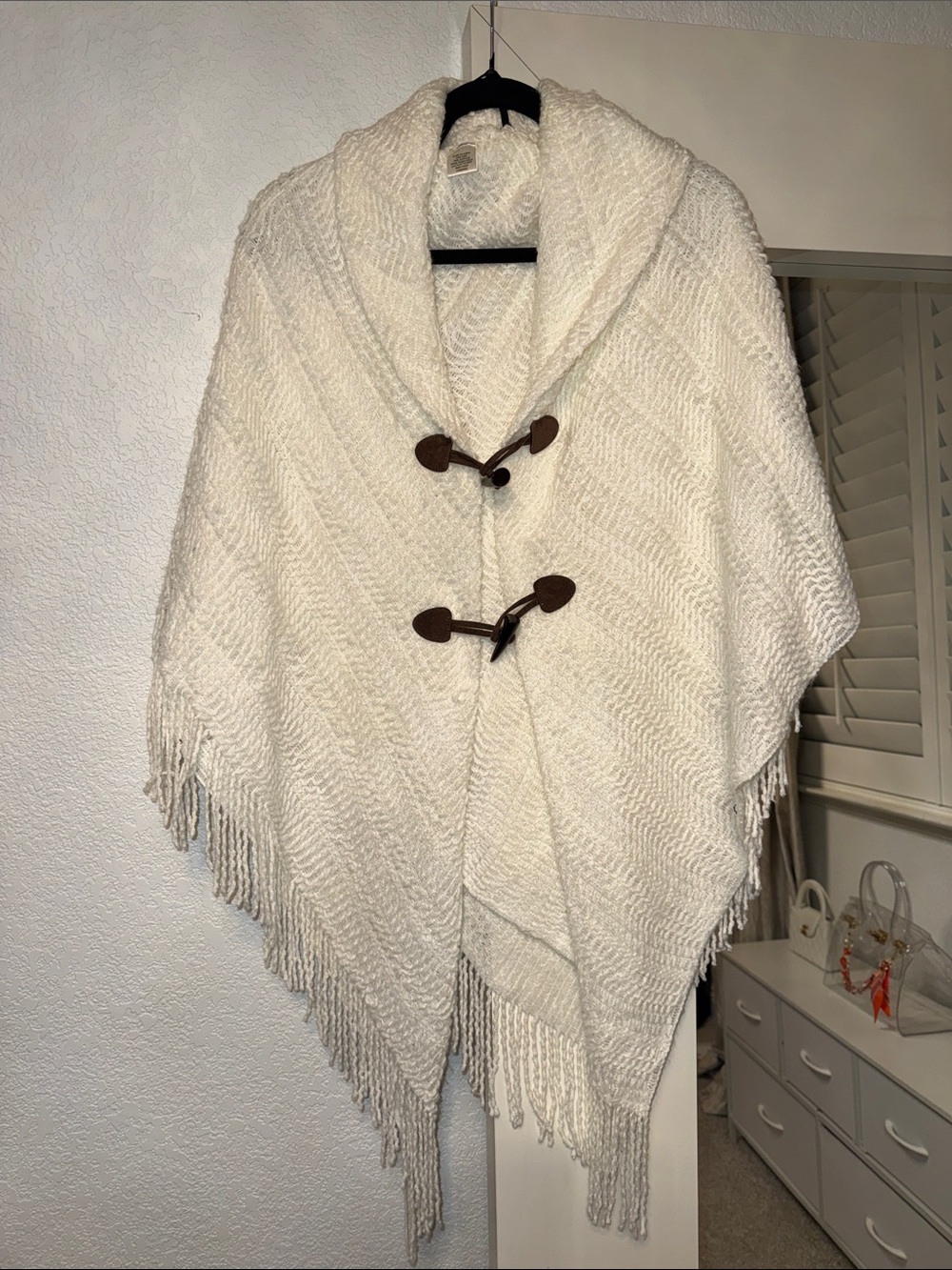 Poncho-like knitted throw with toggles